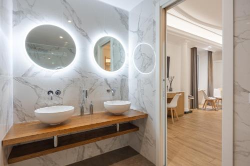 a bathroom with two sinks and two mirrors at SM Vatican Relais B&B in Rome