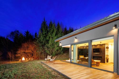 una casa con terrazza in legno di notte di Valdora - Forest Oasis 