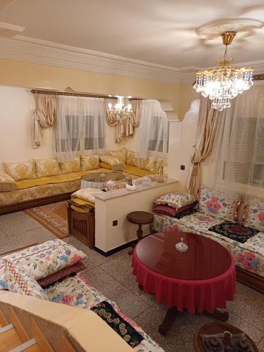 uma sala de estar com um sofá e uma mesa em Spacieux et familial à 2 minutes à pied du stade de football de RABAT em Rabat