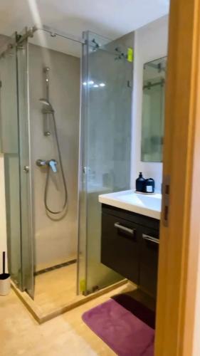 a bathroom with a glass shower and a sink at Studio de standing à maarif in Maarif