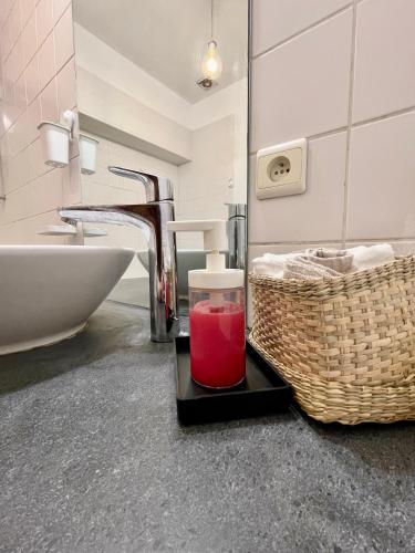 a bathroom with a sink and a glass of red liquid at Central Hub in Brussels