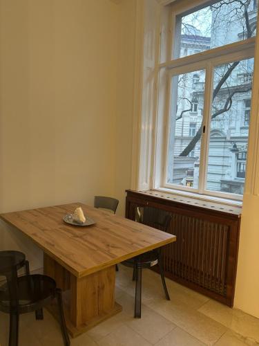 een houten tafel en stoelen in een kamer met een raam bij Apartments Old City Center in Wenen