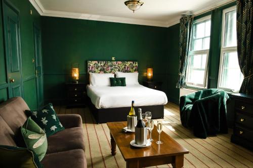 a green room with a bed and a couch at The Royal Oak Hotel in Ramsgate