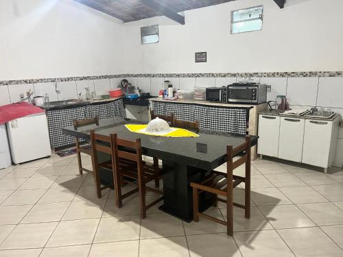 eine Küche mit einem Tisch und Stühlen darin in der Unterkunft Chácara do Sossego in Viçosa do Ceará