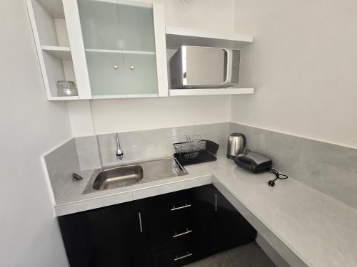 a kitchen with a sink and a microwave at TRADEL Loreto in Iquitos