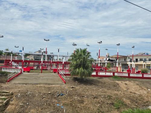 伊基托斯TRADEL Loreto的有红色栅栏和棕榈树的公园