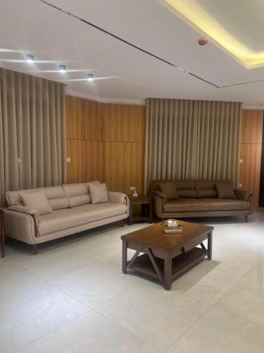 uma sala de estar com dois sofás e uma mesa de centro em الكوت للأجنحة السكنية - Alkout Suites em Irbid