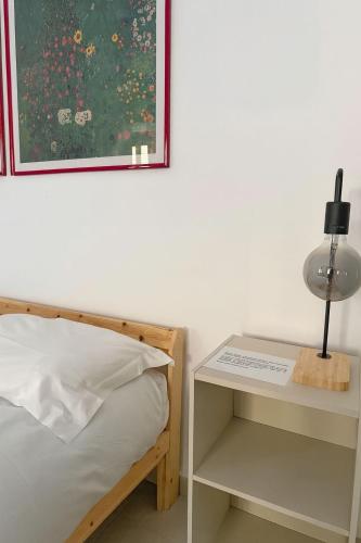 um quarto com uma cama e uma mesa com um abajur em Giuditta Room em Ciriè