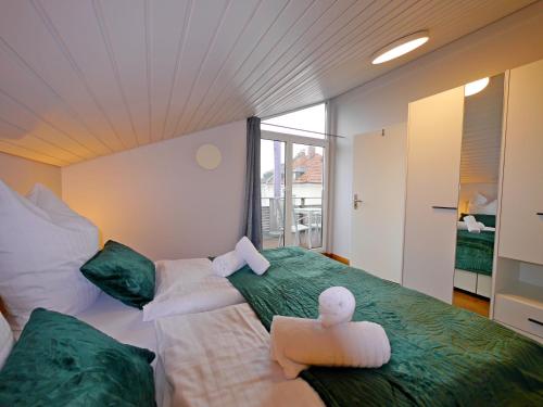 Kurpark Suites Bad Aibling في باد ايبلنغ: غرفة نوم بسريرين يوجد عليها حيوانات محشوة