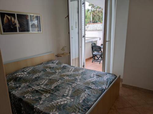 ein Schlafzimmer mit einem Bett und einer Tür zu einem Balkon in der Unterkunft Sea view house, private parking, WiFi in Badesi