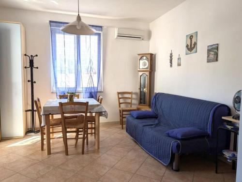 ein Wohnzimmer mit einem blauen Sofa und einem Tisch in der Unterkunft Sea view house, private parking, WiFi in Badesi