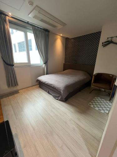 a bedroom with a bed and a window and a chair at 하늘정원 in Gwangju
