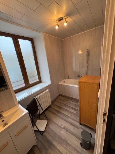 a bathroom with a tub and a sink at Charmante maison de ville in Ancerville