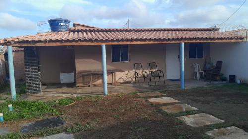 een patio met een dak met een tafel en stoelen bij Casa do ViajanteBr in Barreirinhas