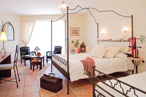 a bedroom with a four poster bed and a desk at Hotel La Sapinière in Brioude