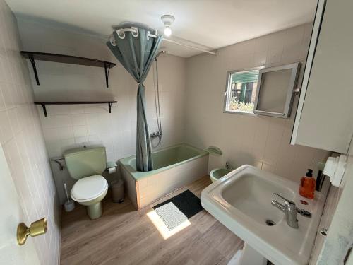 een badkamer met een bad, een toilet en een wastafel bij A Casiña de Coles in Gustey