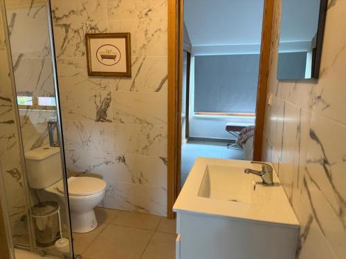 a bathroom with a sink and a toilet at 3 Marias São Sebastião in Lousa