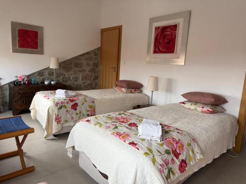 a hotel room with two beds and a table at 3 Marias São Sebastião in Lousa