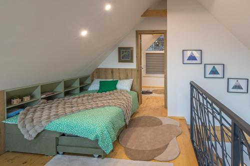 布莱德Počitniška hiša Gorski Šepet Bled的阁楼上一间卧室配有绿色的床