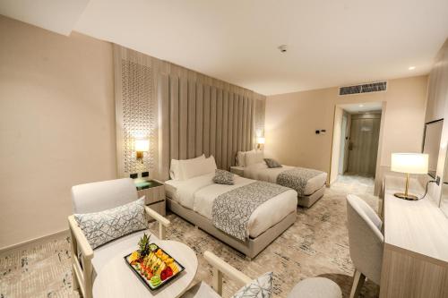 Una habitación de hotel con dos camas y una sala de estar. en Petra Pillars Luxury Hotel, en Petra