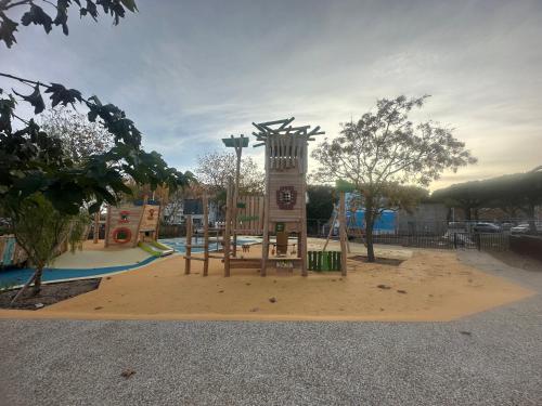 un parque infantil con una torre de reloj en CaroCarnon, en La Celle-sous-Gouzon