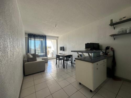 Una cocina y una sala de estar con un sofá y una mesa. en CaroCarnon, en La Celle-sous-Gouzon