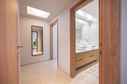 a bathroom with two sinks and a mirror at Aurelia Residence in Ampavris