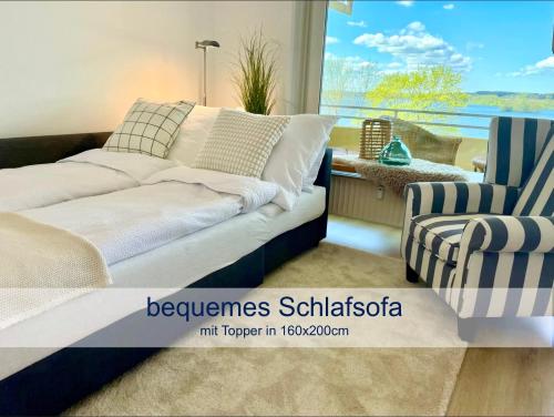 ein Schlafzimmer mit einem Bett, einem Stuhl und einem Fenster in der Unterkunft Heimathafen Dieksee in Malente