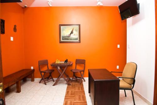 a dining room with orange walls and a table and chairs at Orange - Casa de Hóspedes - modelo Pousada in Rio de Janeiro