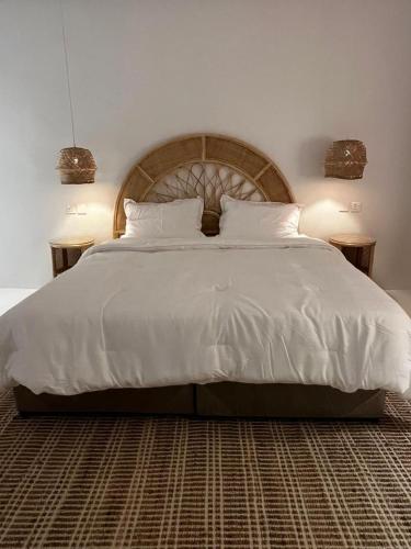 una camera da letto con un grande letto bianco con due lampade di Chalet with a modern bohemian design a Riyad