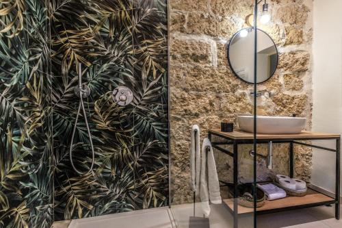 a bathroom with a black and gold leaf wallpaper at Vintage Rooms in Palermo