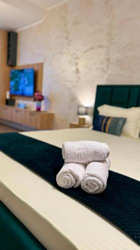 two towels on a bed in a hotel room at SHoliday Sky Panoramic Apartment New Building Private Parking in Timişoara