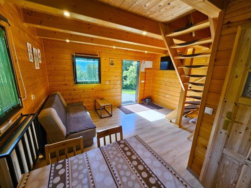 a room with a couch and stairs in a log cabin at Domki Mosorczyk in Zawoja