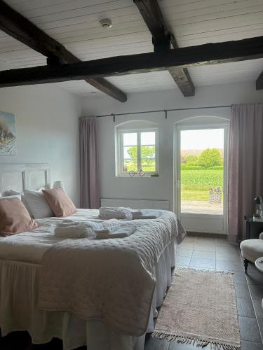 a bedroom with a large bed and two windows at Glivarpagården in Hammenhög