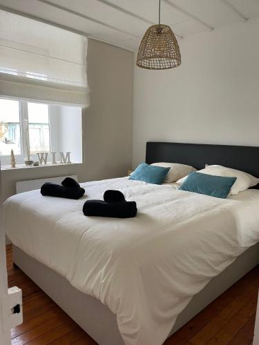 a bedroom with a large white bed with blue pillows at Le Wim Break, Centre et Mer à 2 pas in Wimereux
