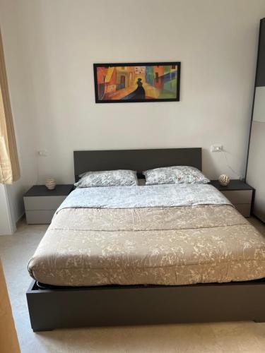 a bedroom with a bed and a picture on the wall at Capitan Ale in Sanremo