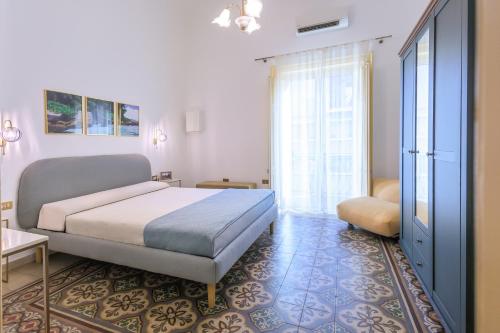 a bedroom with a bed and a large window at Vintage Rooms in Palermo