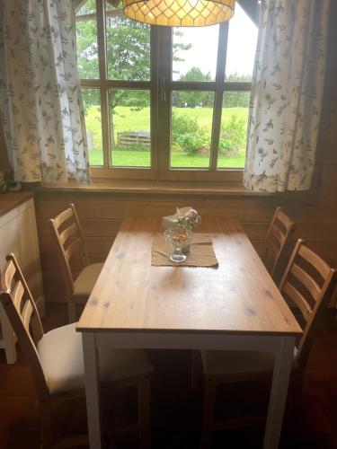 a dining room table with chairs and a window at Charmant Studio in Mattsee
