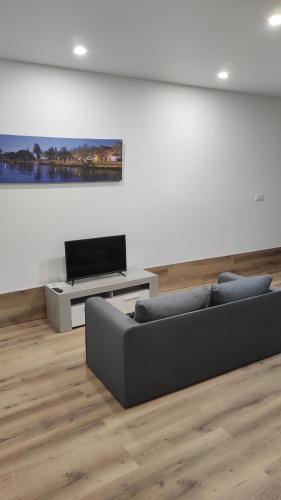 a living room with a couch and a flat screen tv at Casa da Praça in Murtosa