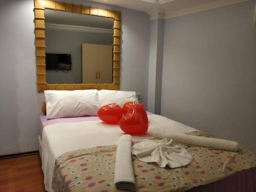 アンタルヤにあるNest Hotel Antalyaのボクシンググローブ2つと鏡のあるベッド