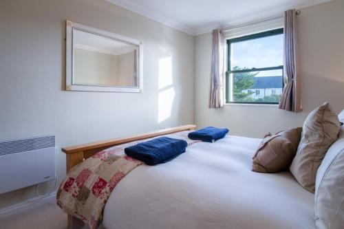 Un dormitorio con una cama con almohadas azules. en 13 St Brides Bay View - 4 Bedroom - Broad Haven, en Broad Haven