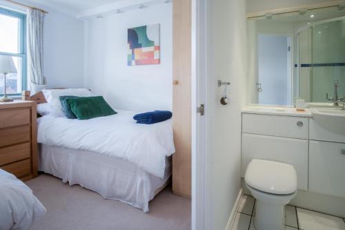 Un dormitorio con una cama, un lavabo y un inodoro. en 13 St Brides Bay View - 4 Bedroom - Broad Haven, en Broad Haven