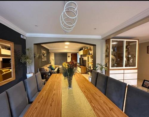 Un comedor con una larga mesa de madera y sillas. en Linda Casa Barrio Privado, en Yerba Buena