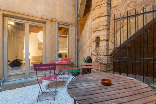 un patio avec une table et des chaises en bois dans l'établissement Le 27 L, à Lyon