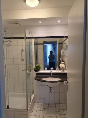 a person taking a picture of a bathroom with a sink at Am Zingster Strand in Zingst
