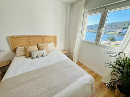 a bedroom with a large bed with a large window at RÍA LIVING - Mar 03 in Cee