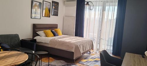 a bedroom with a bed and a table and chairs at Planet-A1012 in Niš