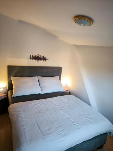 a bedroom with a white bed with two white pillows at Hills View Apartment in Donovaly