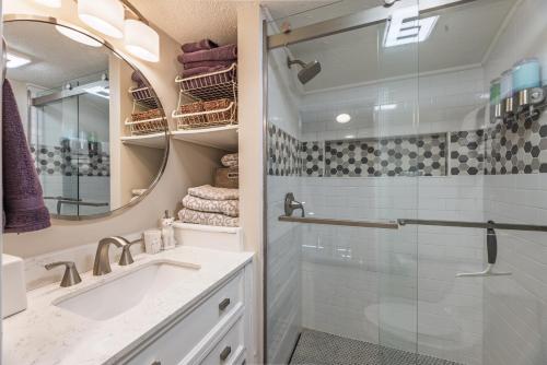 un bagno con doccia, lavandino e specchio di Mountain Crest Cabin a Snowshoe