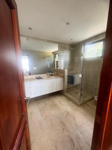 a bathroom with a shower and a large mirror at Penthouse con vistas espectaculares del Lago de Atitlán in Panajachel